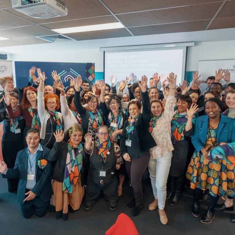 Group photo of launch attendees raising their arms together